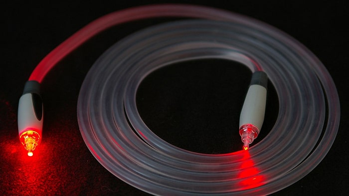 تصویر یک کابل فیبرنوری با نورهای نارنجی در داخل